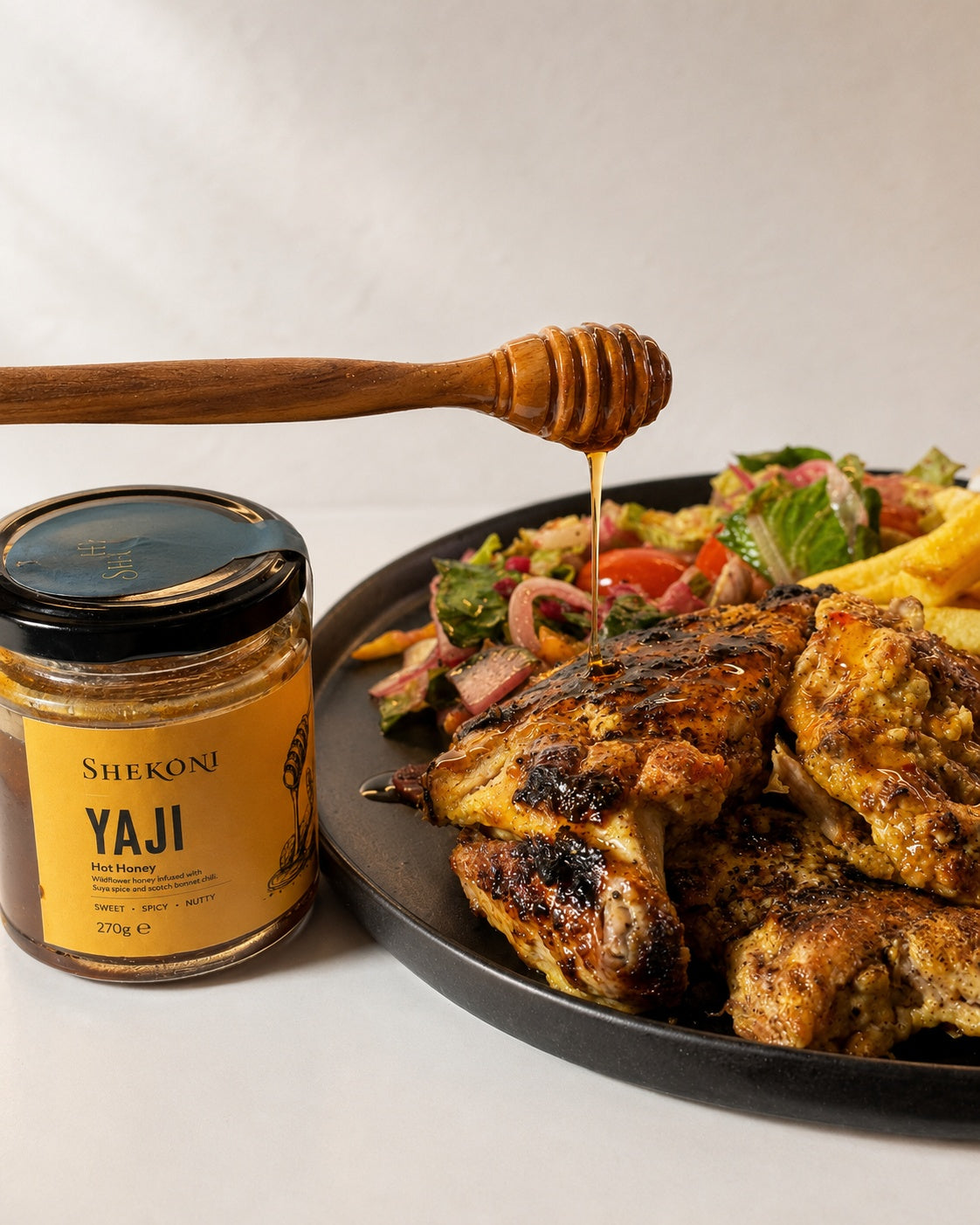Yaji hot honey drizzled over grilled chicken with salad and chips